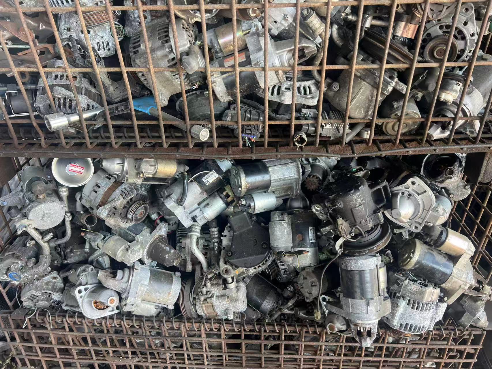 Recovered alternators, starter motors and other automotive parts in storage bins